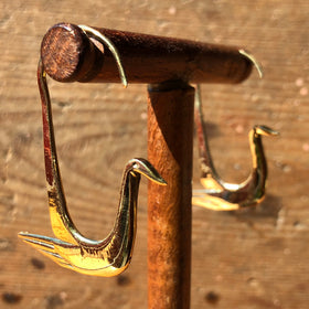 Fair trade brass swan earrings on stand