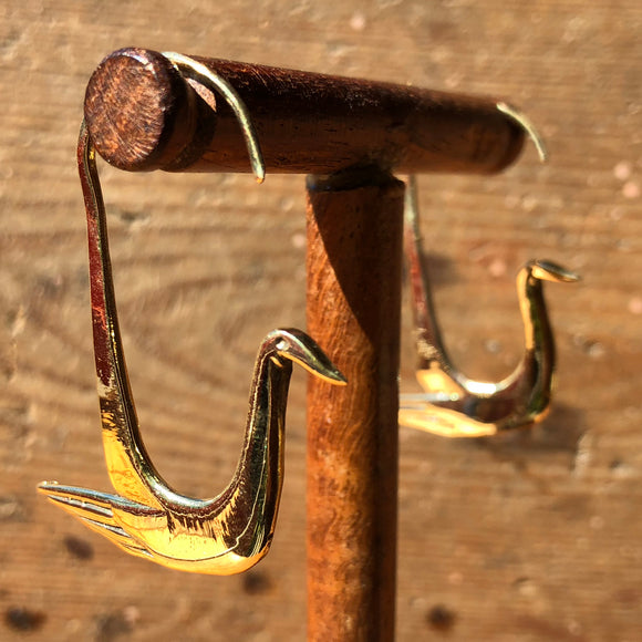 Fair trade brass swan earrings on stand